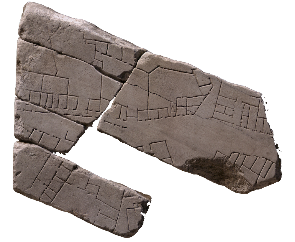 A broken stone fragment with markings on in little squares, lines, and dots.