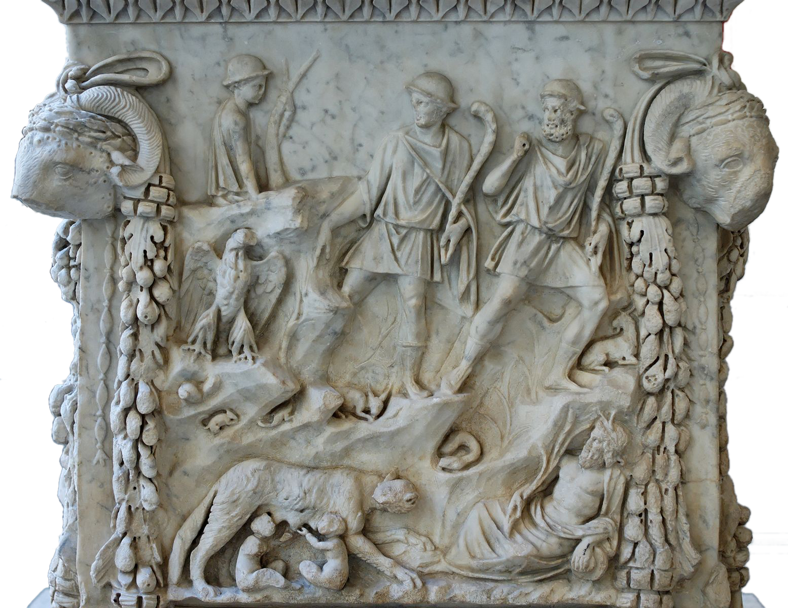The bottom of a carved Roman altar showing Romulus and Remus at the bottom being suckled by a wolf in a cave and then with a shepherd. There is also a depiction of the personified Tiber and an eagle.