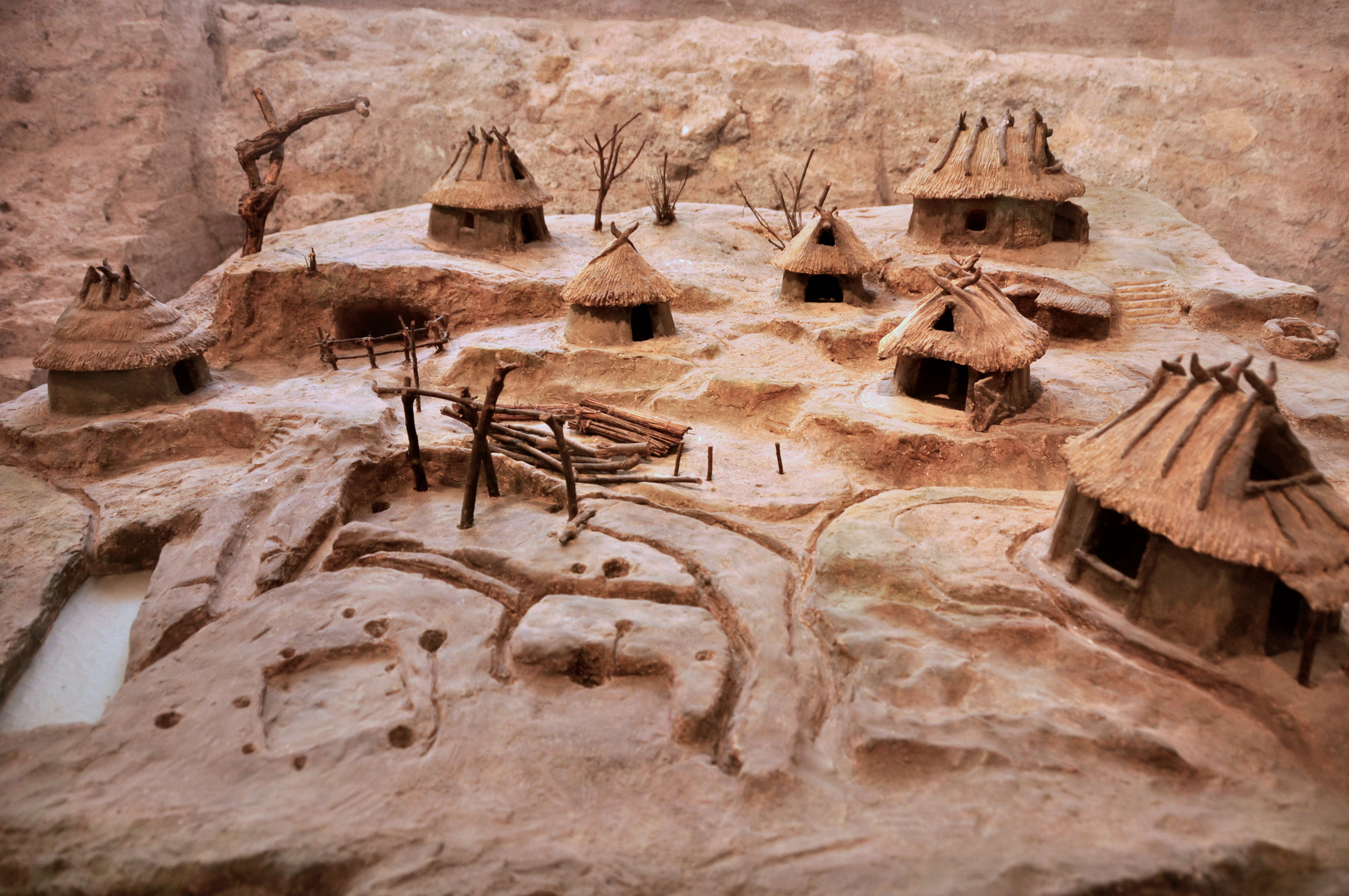 Model of the original settlement. There are huts made of mud, sticks, and straw.